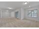 A spacious living room with recessed lighting and neutral carpeting, features a sliding door and view of the outdoors at 1680 Mint River Dr, Apex, NC 27502