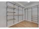A walk-in closet with wooden shelving and metal racks for ample storage and organization at 1680 Mint River Dr, Apex, NC 27502