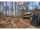A cozy backyard with a stone path leading to a modern home, surrounded by tall trees and lush landscaping at 202 Oxford Hills Dr, Chapel Hill, NC 27514
