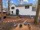 Exterior backyard view of the house, guest house, fire pit, and patio with wooden deck at 202 Oxford Hills Dr, Chapel Hill, NC 27514