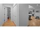 A hallway features hardwood floors, white walls, and leads to the modern kitchen and decorative powder room at 202 Oxford Hills Dr, Chapel Hill, NC 27514