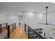 Bright hallway featuring hardwood floors, modern iron railings and built-in bookshelves at 202 Oxford Hills Dr, Chapel Hill, NC 27514