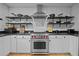 A stainless steel Wolf oven is centered between white cabinets and open shelves against a white tiled backsplash at 202 Oxford Hills Dr, Chapel Hill, NC 27514