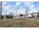 Expansive backyard view showing the home, patio area, outbuildings, trees and lake access at 2118 Timberlake Dr, Raleigh, NC 27604