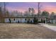 View of the home's exterior showcasing the home's architectural lines, simple landscaping and mature trees at 2118 Timberlake Dr, Raleigh, NC 27604