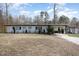 View of the home's exterior showcasing the home's architectural lines, simple landscaping and mature trees at 2118 Timberlake Dr, Raleigh, NC 27604