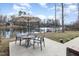 Enjoy this lovely lake view from the outdoor patio featuring a patio table and chairs set under a large umbrella at 2118 Timberlake Dr, Raleigh, NC 27604