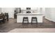 Bright kitchen with stainless steel appliances, hardwood floors, and a stylish island with barstool seating at 213 Suburban Meadow Pass, Wendell, NC 27591