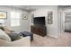 Comfortable living room space with a sofa, media cabinet, and a large window for natural light at 213 Suburban Meadow Pass, Wendell, NC 27591
