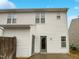 Rear view of the townhome with white siding, a back door and fenced yard at 2356 Bay Harbor Dr, Raleigh, NC 27604