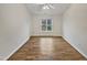 Bright, minimalist bedroom featuring neutral tones, hardwood floors, and a large window for ample natural light at 2356 Bay Harbor Dr, Raleigh, NC 27604