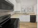 Stylish kitchen featuring black appliances, granite countertops, white cabinets, and view into adjacent living room at 2356 Bay Harbor Dr, Raleigh, NC 27604