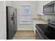 Galley kitchen featuring stainless steel appliances, granite countertops, and modern white cabinetry at 2356 Bay Harbor Dr, Raleigh, NC 27604