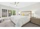 Bright main bedroom with a ceiling fan, plush carpet, and large windows at 248 Sweet Bay Pl, Carrboro, NC 27510