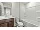 Well-lit bathroom with a single vanity, toilet, and shower/tub combo with white tub surround at 265 Day Farm Dr, Lillington, NC 27546