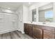 Main bathroom boasts a double sink vanity, modern fixtures, and a glass-enclosed shower with vinyl floors at 265 Day Farm Dr, Lillington, NC 27546
