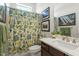 Well-lit bathroom with a marble vanity, decorative shower curtain, and modern fixtures at 2675 Beckwith Rd, Apex, NC 27523