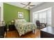 Bright bedroom with a green accent wall, a bay window, and hardwood flooring at 2675 Beckwith Rd, Apex, NC 27523