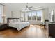 Spacious bedroom with tray ceiling, large windows offering scenic views, and stylish furnishings at 2675 Beckwith Rd, Apex, NC 27523