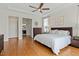 Bright bedroom featuring hardwood floors, neutral decor, and an en-suite bathroom entrance at 2675 Beckwith Rd, Apex, NC 27523