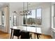 Bright dining room showcasing a modern chandelier and view of the lush backyard scenery at 2675 Beckwith Rd, Apex, NC 27523