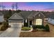Charming home with stone accents, manicured landscaping, and a well-lit two-car garage at 2675 Beckwith Rd, Apex, NC 27523