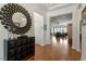 Bright foyer featuring hardwood floors, a modern mirror accent, and an open view to the living space at 2675 Beckwith Rd, Apex, NC 27523