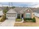 Charming single-story home with a stone facade, a two-car garage, and manicured landscaping at 2675 Beckwith Rd, Apex, NC 27523