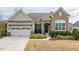 Charming front exterior with stone accents, manicured landscaping, and a two-car garage at 2675 Beckwith Rd, Apex, NC 27523