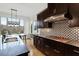 Beautiful kitchen with dark cabinets, gas range and stylish backsplash with adjacent dining area at 2675 Beckwith Rd, Apex, NC 27523