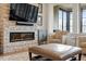 Cozy living room featuring a stone fireplace, large TV, and comfortable seating near natural light at 2675 Beckwith Rd, Apex, NC 27523