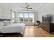 Bright main bedroom boasts a trey ceiling, fan, large windows, and hardwood flooring at 2675 Beckwith Rd, Apex, NC 27523