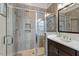 Modern tile shower with glass door and marble countertop with dark cabinets at 2675 Beckwith Rd, Apex, NC 27523