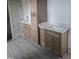 Bathroom vanity with double sinks, granite countertop, wood cabinets, and light wood flooring at 2833 Faucette Ln, Burlington, NC 27217