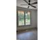 Bright bedroom with a ceiling fan and large window offering a lush green outdoor view and durable flooring at 2833 Faucette Ln, Burlington, NC 27217