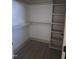 Walk-in closet showcasing ample shelving space, with neutral color palette and durable wood-look flooring at 2833 Faucette Ln, Burlington, NC 27217