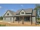 Charming two-story home with a covered front porch, complemented by brick accents and a well-manicured lawn at 2833 Faucette Ln, Burlington, NC 27217