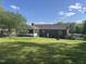 Spacious backyard featuring lush greenery, a screened-in porch, and fenced perimeter at 300 W Carr St, Mebane, NC 27302