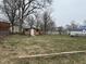 Large backyard with sheds and mature trees providing shade, offering plenty of space for activities at 300 W Carr St, Mebane, NC 27302