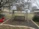 Wooden swing set nestled in mulch bed, creating a cozy and inviting backyard feature at 300 W Carr St, Mebane, NC 27302