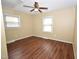 Comfortable bedroom with ceiling fan, wood floors, and natural light from two windows at 300 W Carr St, Mebane, NC 27302