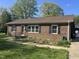 Charming brick home with well-maintained landscaping, black shutters, and inviting entrance at 300 W Carr St, Mebane, NC 27302