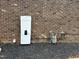 Tankless water heater mounted on brick exterior wall with gas meter, ensuring energy efficient hot water at 300 W Carr St, Mebane, NC 27302