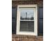 Window with black shutters on brick exterior, adding architectural detail and charm to the home at 300 W Carr St, Mebane, NC 27302