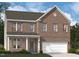 Charming two-story brick home with an attached garage and a covered front porch, offering classic curb appeal at 3205 Shannon Woods Lane # 20, Apex, NC 27523