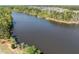 Scenic aerial view of a tranquil lake surrounded by lush greenery, mature trees, and a residential neighborhood at 3215 Jones Lake Rd, Fuquay Varina, NC 27526