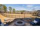 Landscaped backyard with a stone fire pit, black fence, and lake view offers outdoor relaxation at 3215 Jones Lake Rd, Fuquay Varina, NC 27526
