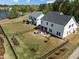 Expansive fenced backyard featuring a stone patio, fire pit, and manicured lawn at 3215 Jones Lake Rd, Fuquay Varina, NC 27526