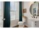 Chic powder room with a pedestal sink, round mirror, and elegant green curtains at 3215 Jones Lake Rd, Fuquay Varina, NC 27526