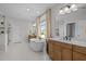 Bright bathroom featuring a soaking tub, glass shower, and dual vanities with wood cabinets at 3215 Jones Lake Rd, Fuquay Varina, NC 27526